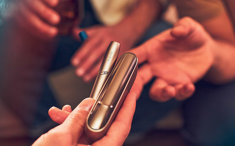 Gold IQOS Duo out of its packaging on a wooden table