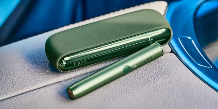 A bright IQOS ILUMA Pocket Charger and Holder in a person's hand.