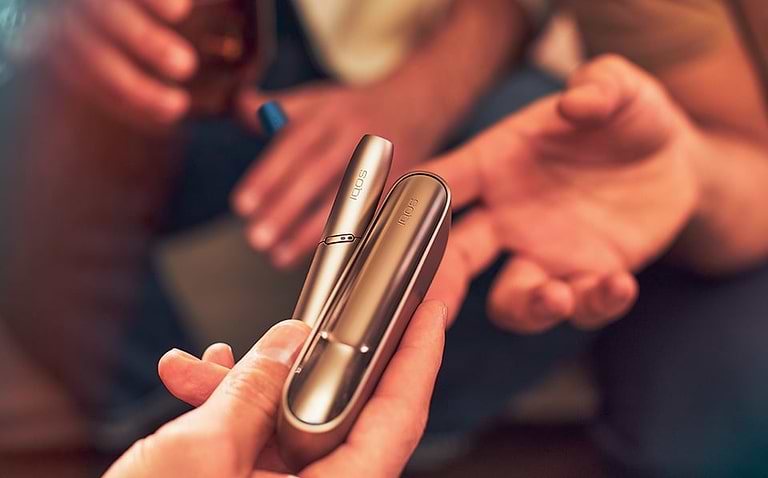 Gold IQOS Duo out of its packaging on a wooden table