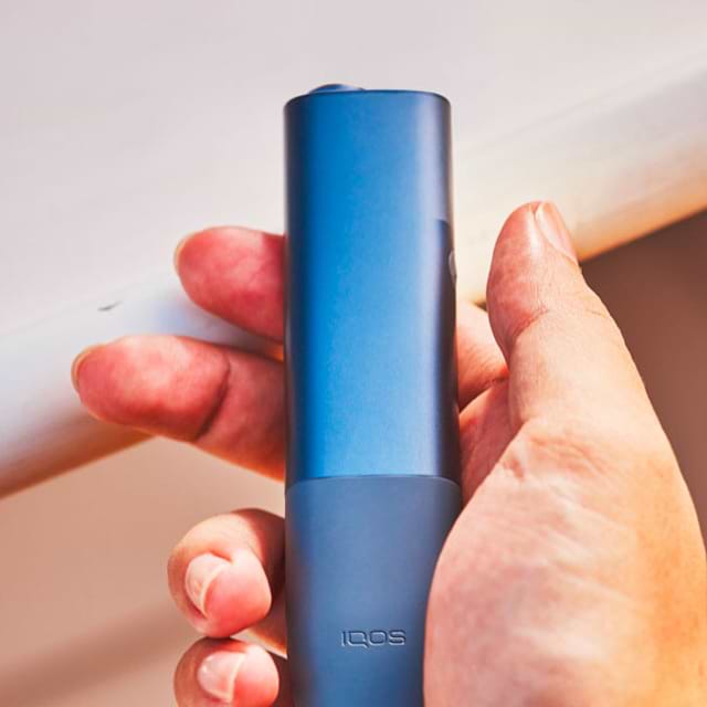 An IQOS ILUMA device and mobile phone.