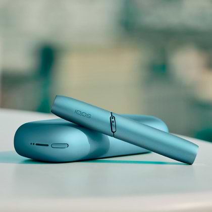 Turquoise IQOS Originals Duo holder and pocket charger on table.	 	 	