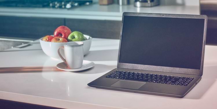 A laptop computer and IQOS device  on a table.