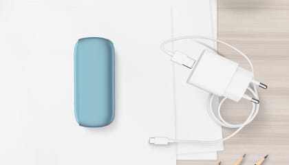 Turquoise IQOS ORIGINALS DUO pocket charger next to cable charger.	