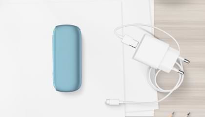 Turquoise IQOS ORIGINALS DUO pocket charger next to cable charger.	 	 	