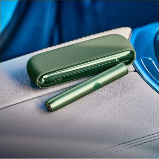 Hands holding IQOS ILUMA PRIME Pocket Chargers.