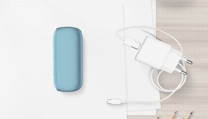 Turquoise IQOS ORIGINALS DUO pocket charger next to cable charger.	