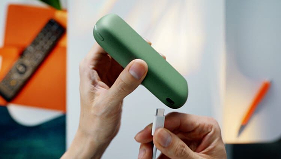 A charging cable being inserted into an IQOS ILUMA Holder.