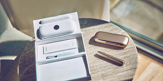 Girl smiling with an IQOS box in her hands