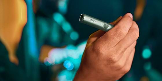 A person placing a TEREA stick into an IQOS ILUMA Holder. 