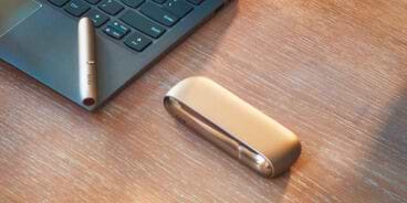 Blond girl with her gold IQOS kit in her hands