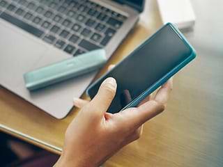Turquoise IQOS Originals One device on a coffee table.	 	 	