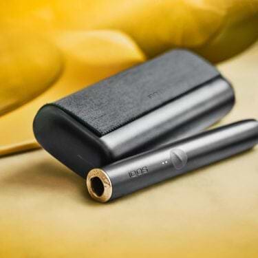 An obsidian black IQOS ILUMA device and holder.