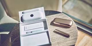 Girl smiling with an IQOS box in her hands