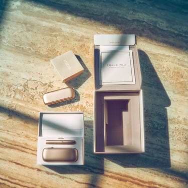 Gold IQOS Duo out of its packaging on a wooden table