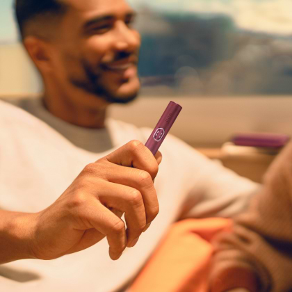 A charging cable being inserted into an IQOS ILUMA PRIME holder.